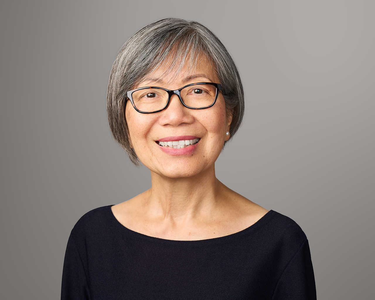Professional business headshot of a woman wearing glasses with a great smile.