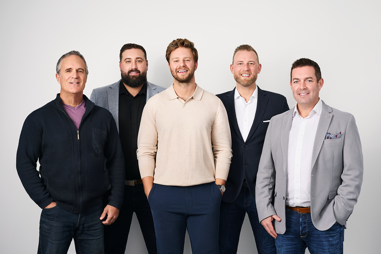 Group portrait of five Mac's II team members, Wes, Derek, Andrew, Chris, and Kyle, in professional attire, posing in Metro Vancouver.