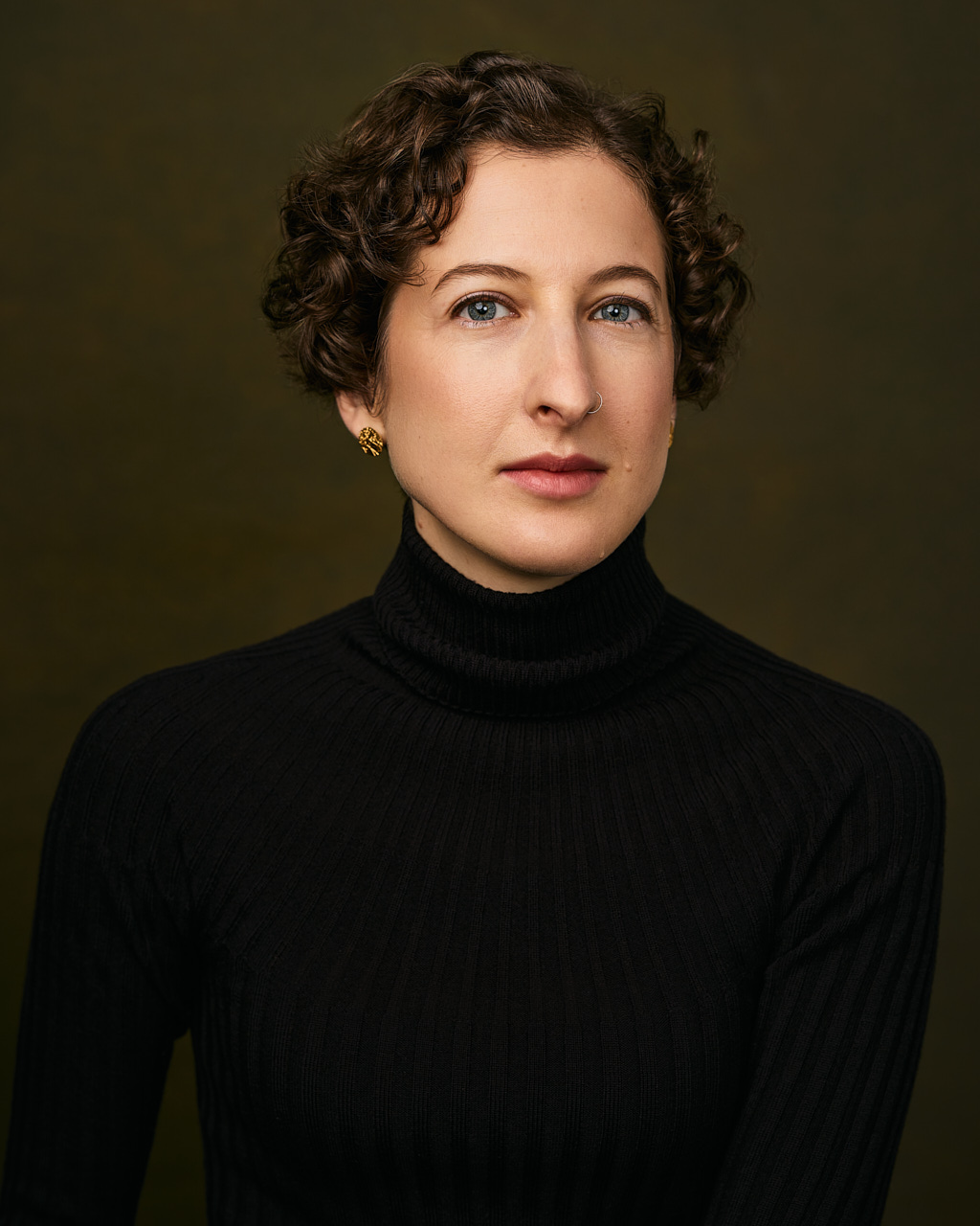 A stunning headshot of a woman wearing a black turtle neck.